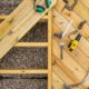 Top down image of a desk under construction showing joists, planks and tools used