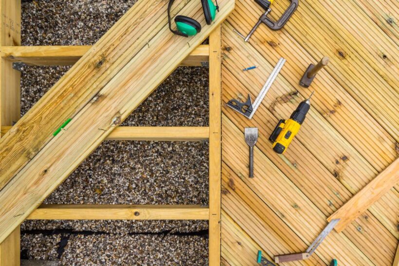 Top down image of a desk under construction showing joists, planks and tools used