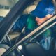 Car Mechanic Fixing Vehicle While Seating Inside the Car. Professional Car Maintenance.